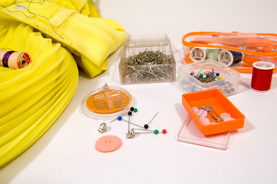 an array of sewing supplies including thread, needles, pins and safety pins